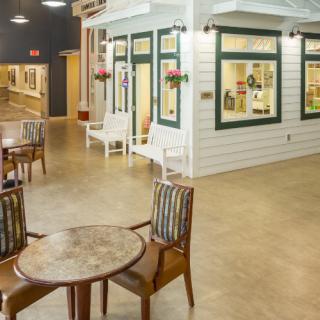 A cozy indoor setting resembling a small village market with tables and chairs.