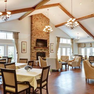 A spacious dining area with a fireplace, chandeliers, and elegant seating arrangements.