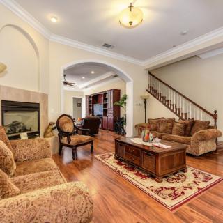 A cozy living room featuring classic furniture, a fireplace, and wooden flooring.