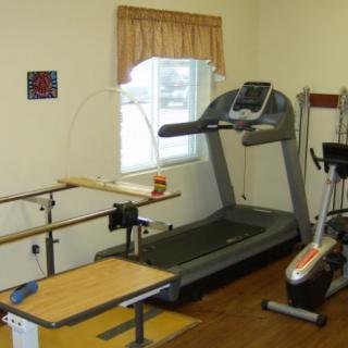 A rehabilitation room equipped with a treadmill and other exercise equipment for physical therapy.