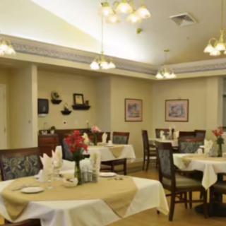 A cozy dining room with elegantly set tables and warm lighting.