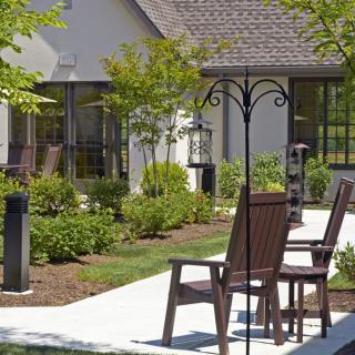A serene outdoor patio area with chairs and lush landscaping.