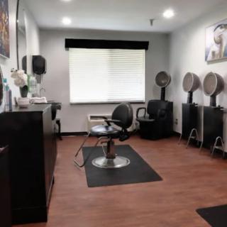 A modern hair salon interior with chairs and hair drying stations.