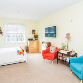 A bright and inviting bedroom featuring colorful furniture and a television.