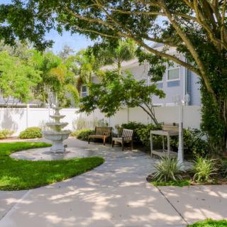 A beautifully landscaped garden with a pathway, fountain, and outdoor seating.