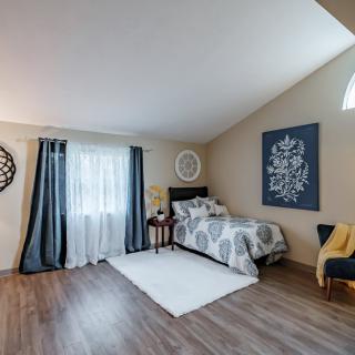 A cozy bedroom featuring a single bed, decorative wall art, and minimalist decor.