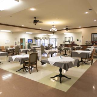 An empty dining area in a restaurant with neatly arranged tables and chairs.