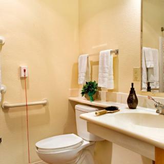A neatly organized bathroom with a sink, toilet, and towel rack.