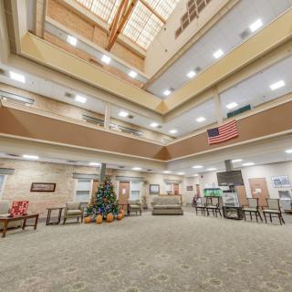 A spacious lobby with a Christmas tree and an American flag, featuring modern interior design and ample seating.