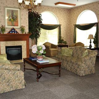 A cozy living room with floral-patterned furniture and a fireplace.