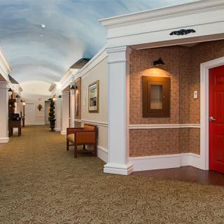 A well-lit hallway with a red door and elegant decor.