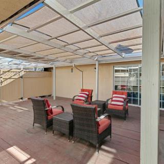 A cozy outdoor patio area featuring comfortable seating and a protective canopy.
