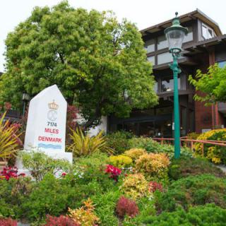 A beautifully landscaped area in front of the Sea Otter Inn with well-maintained plants and a traditional lamp post.