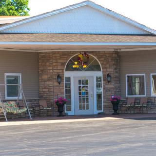 The image shows the entrance to a building with a symmetrical design, featuring double doors and flanked by windows.