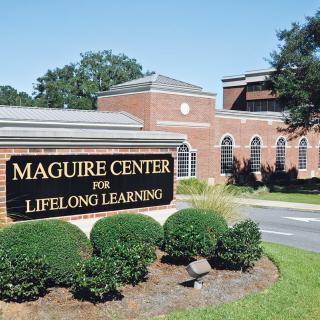 The Maguire Center for Lifelong Learning, showcasing its brick architecture and outdoor signage.