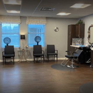 A cozy hair salon interior with chairs and salon equipment.