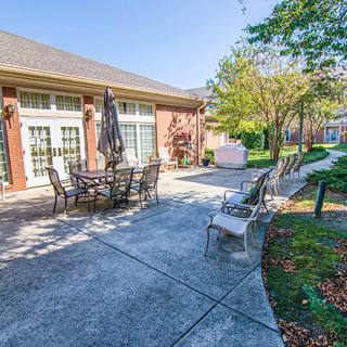 A spacious patio area with outdoor seating and a well-maintained garden on a sunny day.