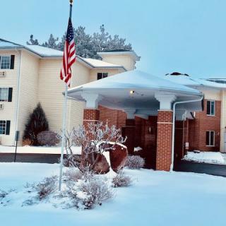 A snowy scene featuring a building with an American flag outside.