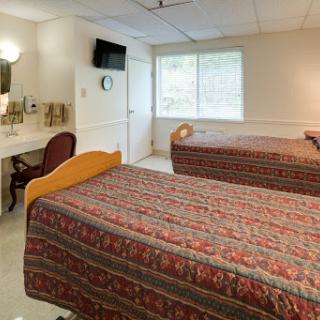 Cozy hotel room featuring two beds and natural light.