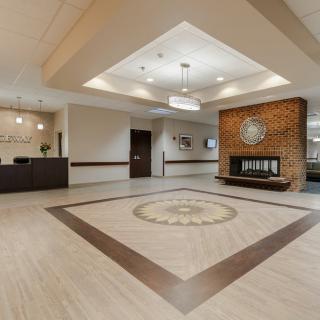 A modern lobby with a reception desk and a decorative fireplace.