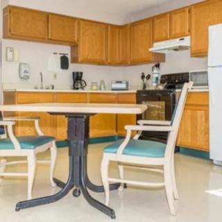 A cozy kitchen with wooden cabinets, a dining table, and chairs.
