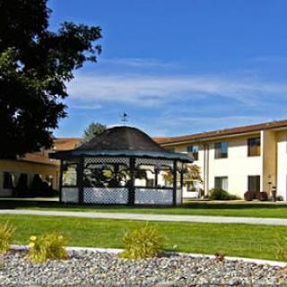 A scenic view of a gazebo and building set against a clear blue sky.