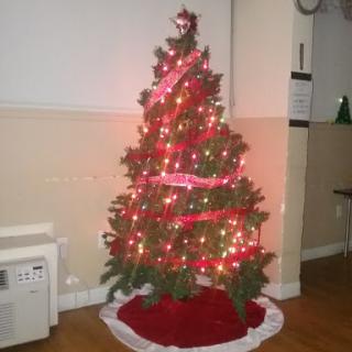 A beautifully decorated Christmas tree adorned with lights and red ribbons.