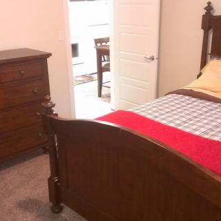 A cozy bedroom with wooden furniture and a neatly made bed.