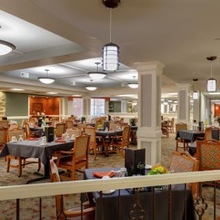 A spacious and elegantly designed dining area with a blend of modern decor and comfortable seating.