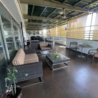 A spacious balcony with cozy outdoor seating and potted plants.
