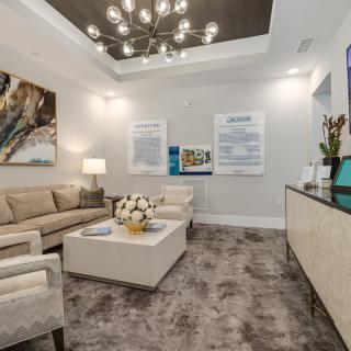 A modern waiting room with comfortable seating, stylish lighting, and decorative artwork.