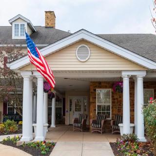 The entrance of a building with columns and an American flag displayed.