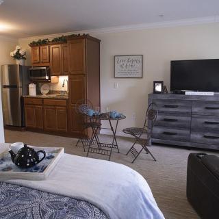 A cozy studio apartment with a kitchenette and living area.