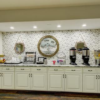 A well-organized breakfast area featuring coffee and beverage dispensers on a countertop with decorative elements.