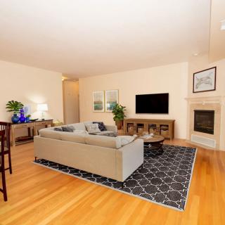 A modern living room with a cozy setup featuring a sofa, television, and fireplace.
