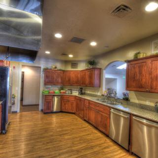 A spacious and modern kitchen with wooden cabinets and stainless steel appliances.