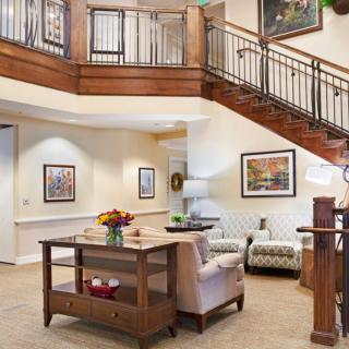 A cozy living room interior with elegant wooden staircase and stylish decor.