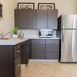 A modern kitchen with dark wood cabinets and stainless steel appliances.