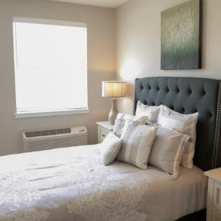 A cozy and modern bedroom featuring a tufted headboard, soft bedding, and a serene ambiance.