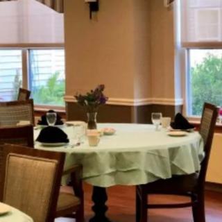 A neatly set dining table with a floral centerpiece in a restaurant interior.