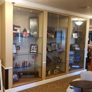 A glass display case showcasing various trophies and memorabilia in an interior setting.