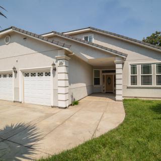 A suburban residential house with a two-car garage and a well-maintained lawn.