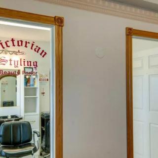 Interior view of a vintage-style barber shop with a styling chair and mirror.