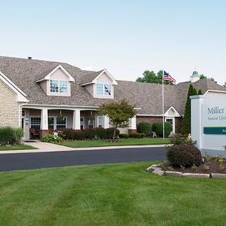 A residential-style building with a well-maintained lawn and a sign in front.