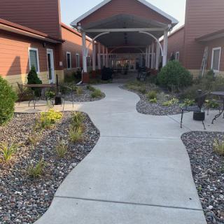 A serene pathway surrounded by landscaped gardens leading to an entrance.