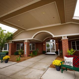 Main entrance of a building with a covered walkway and decorative landscaping.