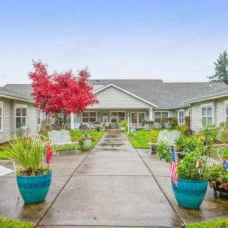 A beautifully landscaped courtyard with potted plants and a pathway leading to a building.