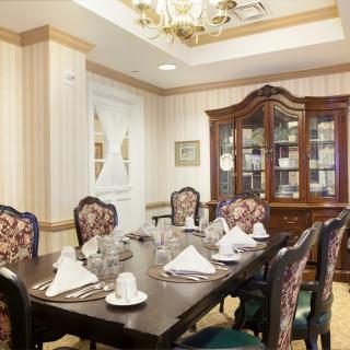 An elegantly furnished dining room with a set table and chandelier.