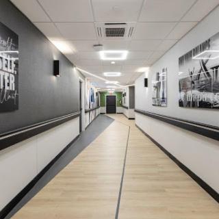 A modern hallway featuring artwork on the walls and sleek flooring.