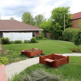 A peaceful garden with raised beds and a well-maintained lawn.